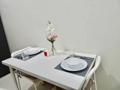 a white table with two plates and a vase of flowers at Casa Laelia in Manila