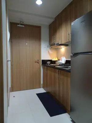 a kitchen with a stainless steel refrigerator and wooden cabinets at Casa Laelia in Manila