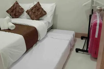 a hotel room with a bed and a suitcase at Casa Laelia in Manila
