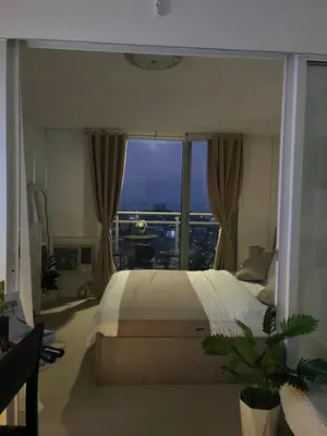 a bedroom with a large bed and a large window at CozyCorner By R&K in Manila