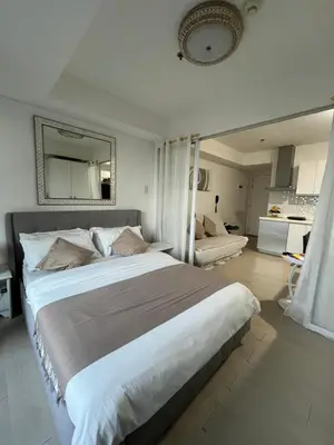 a bedroom with a large bed with a large mirror at CozyCorner By R&K in Manila