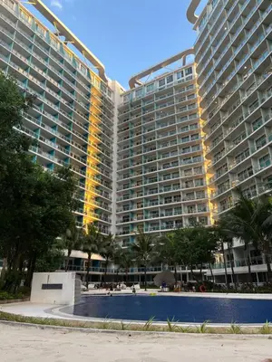 a large apartment building with a pool in front of it at CozyCorner By R&K in Manila