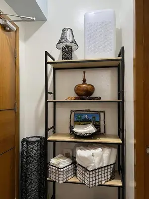 a shelf with towels and a fan in a room at The Morgan Residences in Manila