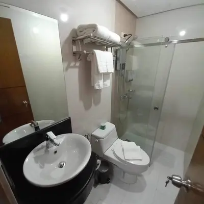 a bathroom with a sink and a toilet and a shower at The Morgan Residences in Manila