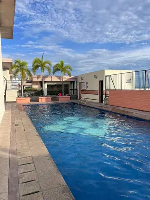 a large swimming pool in a building with palm trees at The Morgan Residences in Manila