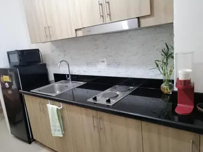 a kitchen with a sink and a black counter top at Classy Stay in Manila