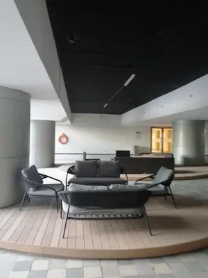 a living room with couches and chairs on a rug at Classy Stay in Manila