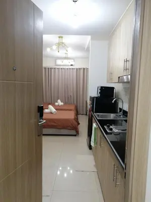 a room with a bedroom with a bed and a kitchen at Classy Stay in Manila