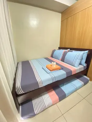 a bedroom with a bed with a tray on it at Budget Condo in Mall Of Asia in Manila