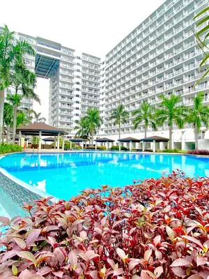 a swimming pool with a large building in the background at Budget Condo in Mall Of Asia in Manila