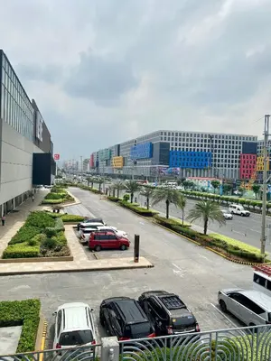 a parking lot with cars parked in front of a building at Budget Condo in Mall Of Asia in Manila