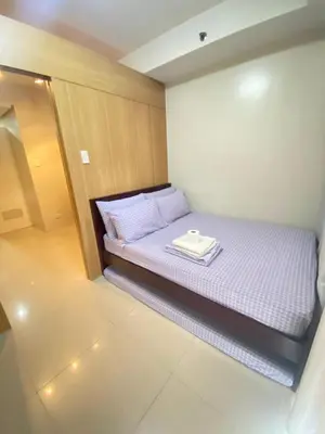 a small bedroom with a bed with a tray on it at Budget Condo in Mall Of Asia in Manila