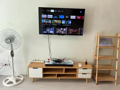 a room with a desk and a fan and a wall at Ports Den in Manila