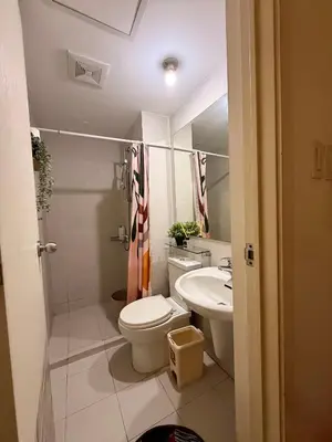 a bathroom with a toilet and a sink at SYM staycation at Azure in Manila