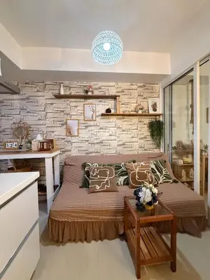 a bedroom with a bed and a brick wall at SYM staycation at Azure in Manila