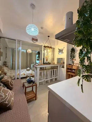 a kitchen and living room with a couch and a table at SYM staycation at Azure in Manila