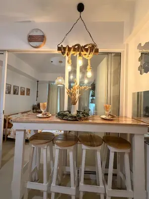 a kitchen with a large table with stools at SYM staycation at Azure in Manila