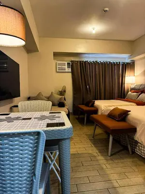 a hotel room with two beds and a table at Staycation in Manhattan near Smart Araneta in Manila
