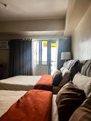 a bedroom with two beds and a window at Staycation in Manhattan near Smart Araneta in Manila