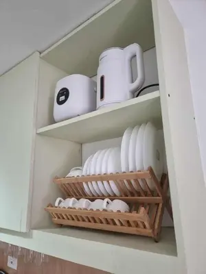 a cupboard filled with plates and cups and dishes at 1569 Shore Residences MOA in Manila