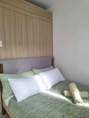 a bed with two pillows on it in a room at 1569 Shore Residences MOA in Manila