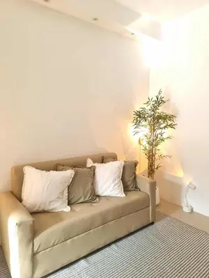 a couch in a living room with a plant at 1569 Shore Residences MOA in Manila
