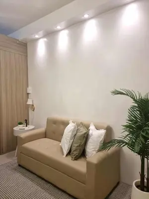 a living room with a couch with pillows on it at 1569 Shore Residences MOA in Manila