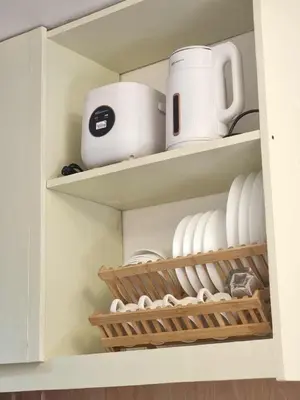 a cupboard filled with plates and cups and dishes at 1569 Shore Residences MOA in Manila