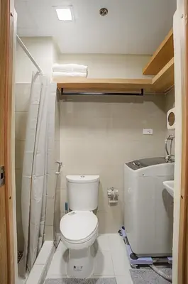 a small bathroom with a toilet and a sink at Relaxing 1BR Balcony with Pool View Plus Free Parking in Manila