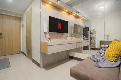 a living room with a tv on a wall at Relaxing 1BR Balcony with Pool View Plus Free Parking in Manila