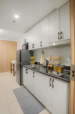 a kitchen with white cabinets and stainless steel appliances at Relaxing 1BR Balcony with Pool View Plus Free Parking in Manila