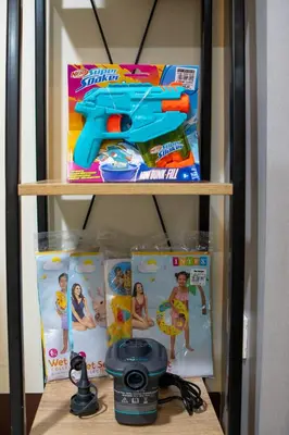 a shelf with a toy gun and other toys at Relaxing 1BR Balcony with Pool View Plus Free Parking in Manila