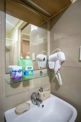 a bathroom with a sink and a mirror at Relaxing 1BR Balcony with Pool View Plus Free Parking in Manila