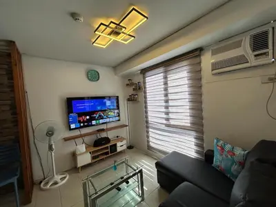 a living room with a couch and a flat screen tv at Ports crib in Manila