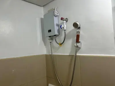 a shower in the corner of a bathroom at Ports crib in Manila