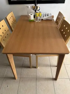 a wooden dining table with two chairs around it at Ports crib in Manila