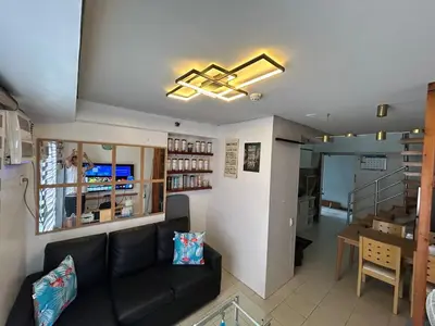 a living room with a couch and a dining room at Ports crib in Manila