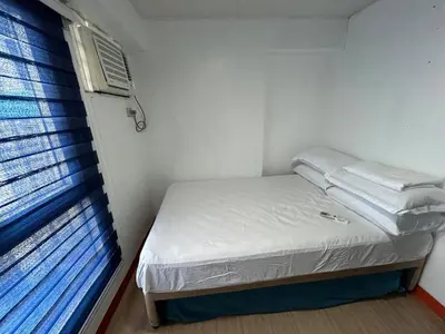 a small room with a bed and a window at Ports crib in Manila
