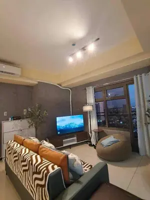 a living room with a couch and a television at The Grand Lower Penthouse 2 Bedrooms, 3 Baths in Manila