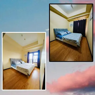 two beds in a small room with wood floors at The Grand Lower Penthouse 2 Bedrooms, 3 Baths in Manila