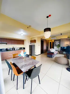 a large living room with a table and chairs at The Grand Lower Penthouse 2 Bedrooms, 3 Baths in Manila