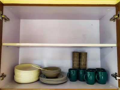 a shelf with bowls and plates in a cabinet at The Grand Lower Penthouse 2 Bedrooms, 3 Baths in Manila