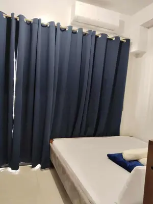 a bed with a blue curtain in a room at SHORe 2 TOWER 3 UNIT 746 in Manila