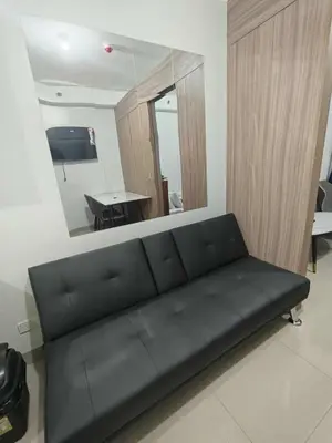 a black couch in a living room with a mirror at SHORe 2 TOWER 3 UNIT 746 in Manila