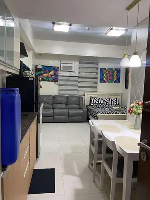 a kitchen and living room with a couch and a table at Vienna Condotel at 101 Newport Blvd in Manila