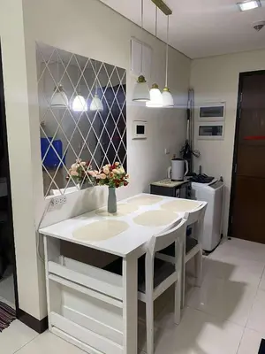 a kitchen with a white island with two sinks at Vienna Condotel at 101 Newport Blvd in Manila