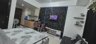 a room with a bed and a kitchen with a wall at Vienna Condotel at 101 Newport Blvd in Manila