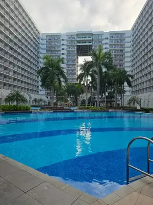 a large swimming pool in front of two large buildings at Neo-Classic 1BR with WiFi Netflix at Shell Res near MOA and NAIA Airport in Manila