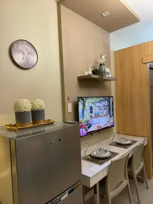 a room with a table with a computer and a clock at Neo-Classic 1BR with WiFi Netflix at Shell Res near MOA and NAIA Airport in Manila