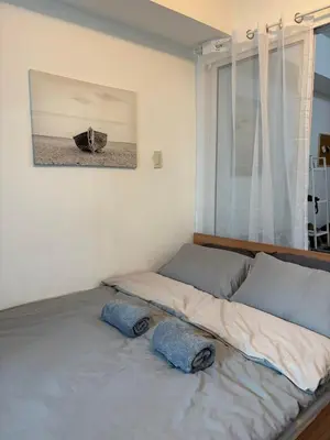 two beds in a room with a window at Anasa Suites in Manila